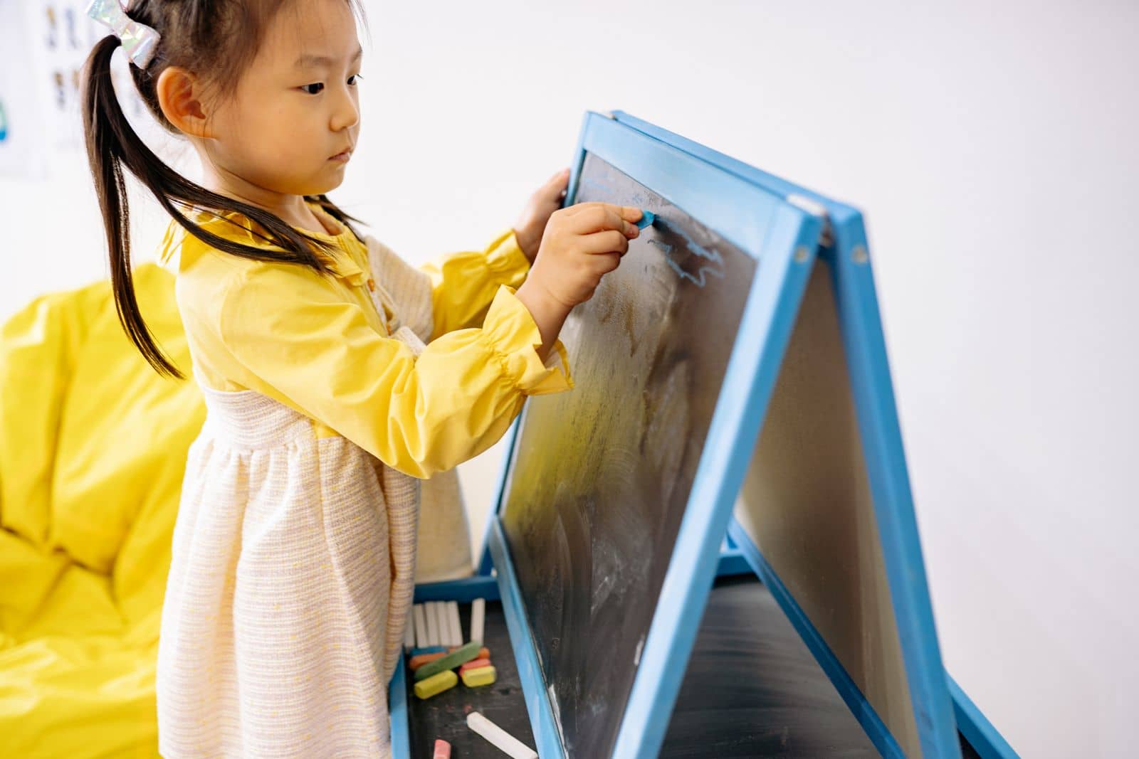 Preschool child drawing with colorful chalk in a creative classroom activity